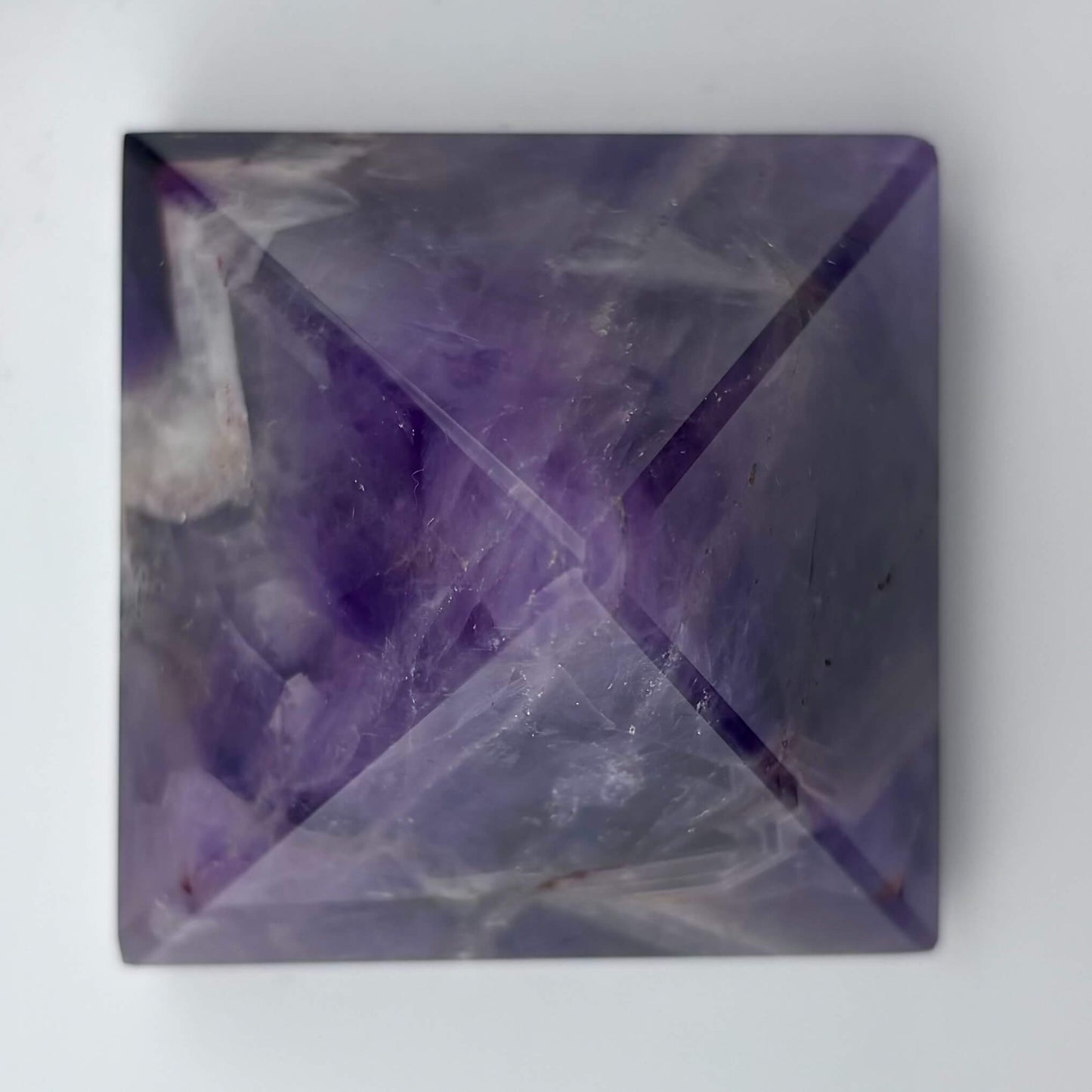 Square crystal with purple and white patterns on a gray background