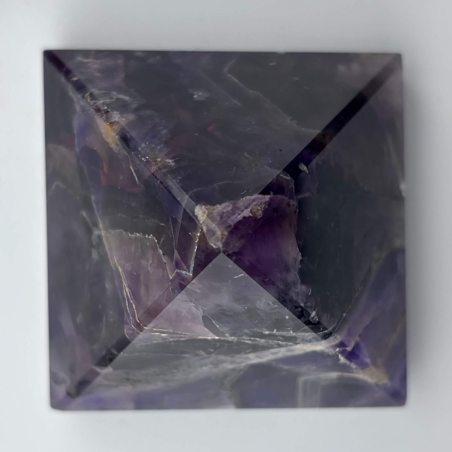 Geometric crystal with purple and gray coloration on a white background