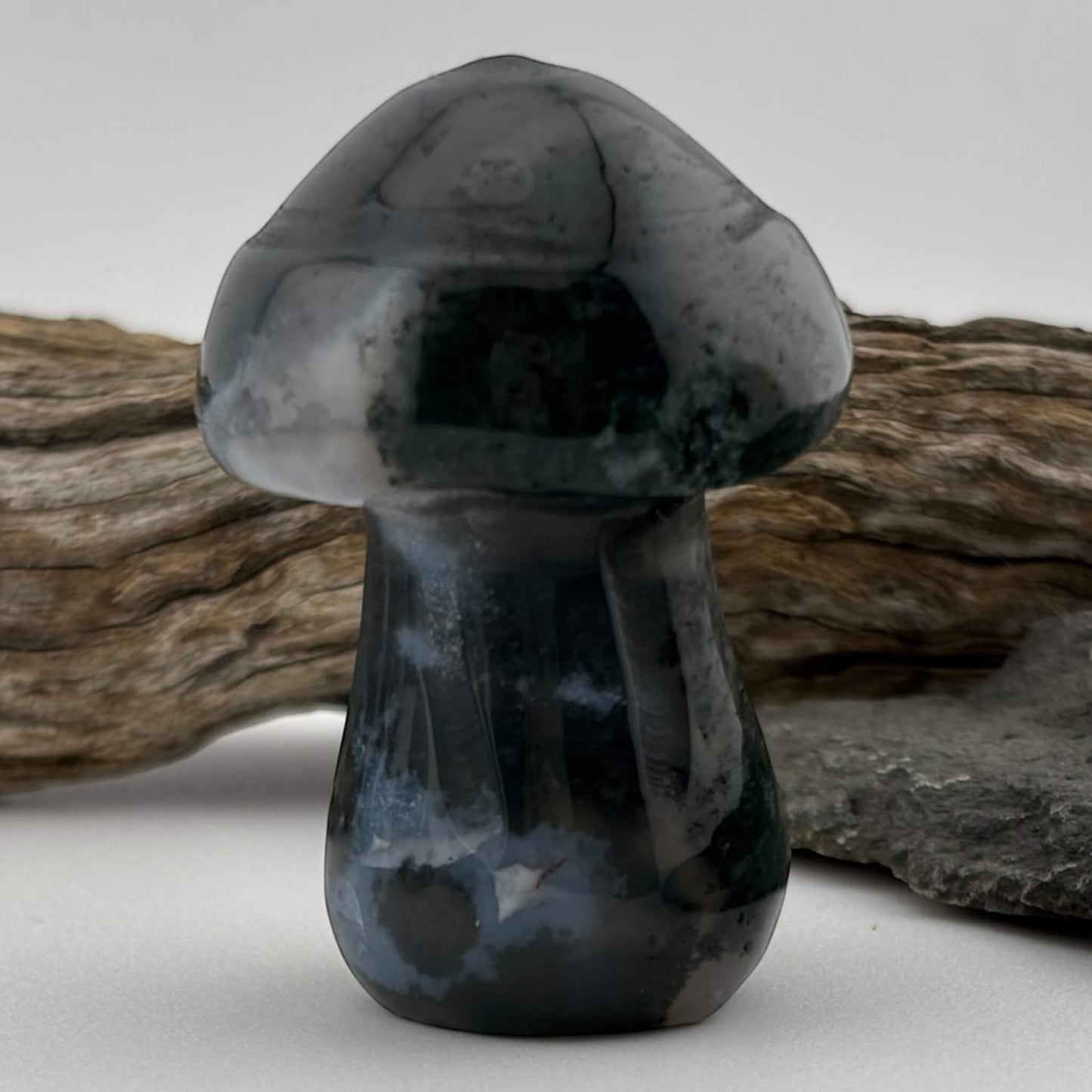 Black and gray stone mushroom sculpture on a neutral background