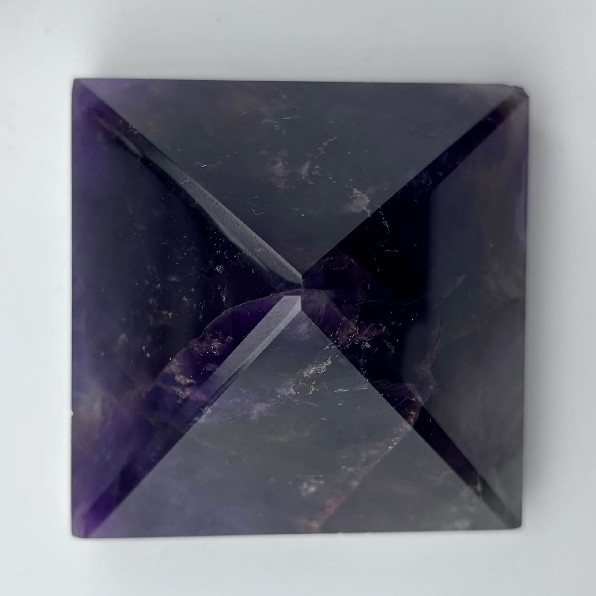 Amethyst crystal pyramid on a white background