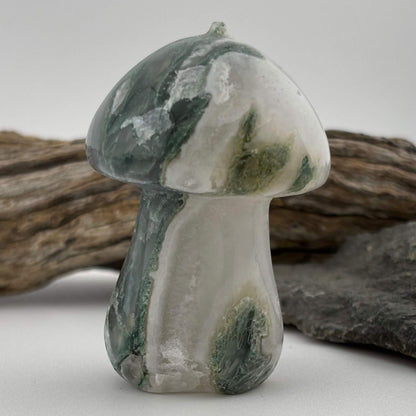 Decorative stone mushroom with green and white patterns on a neutral background