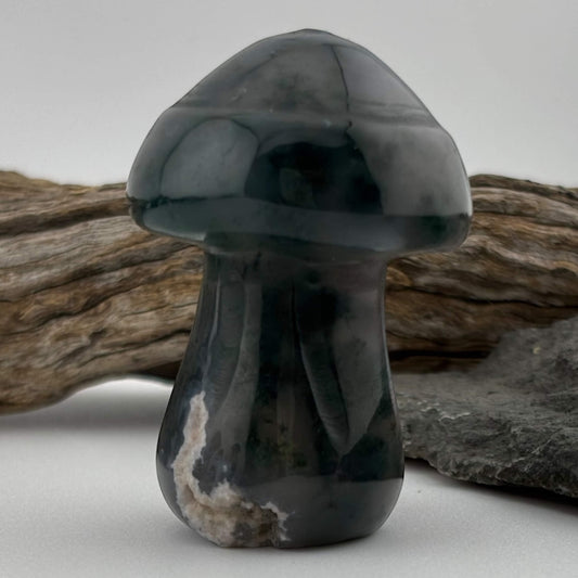Stylized black and gray stone mushroom sculpture on a neutral background