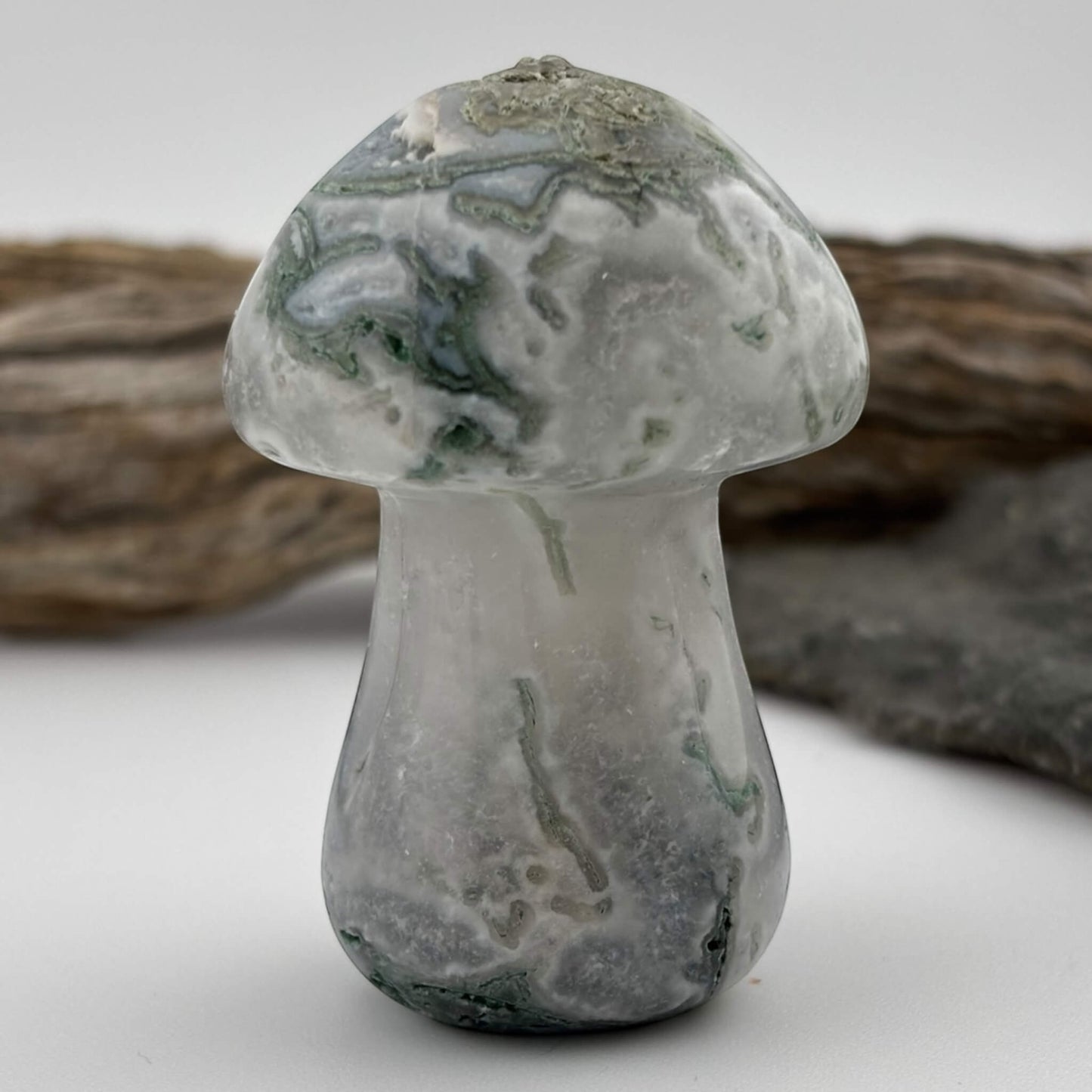 Glass mushroom-shaped object with a textured surface on a neutral background