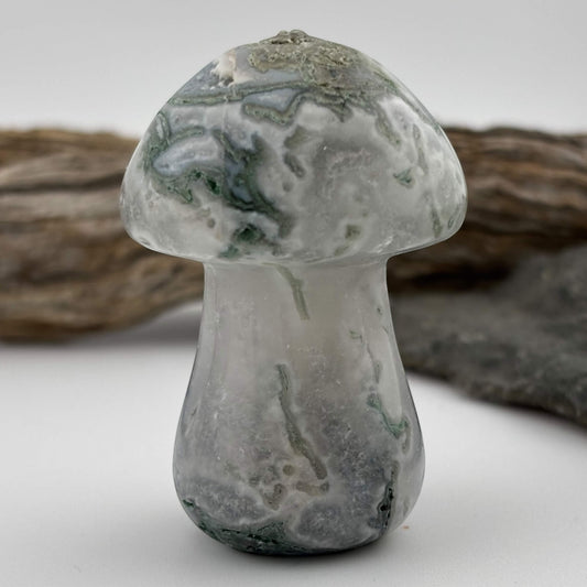 Glass mushroom-shaped object with a textured surface on a neutral background