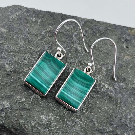 Malachite  rectangular earrings on a gray stone surface